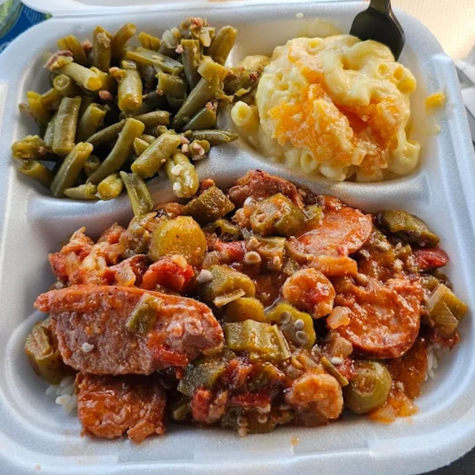 Tony's Seafood cajun meal with gumbo, green beans, and macaroni and cheese in a takeout container.
